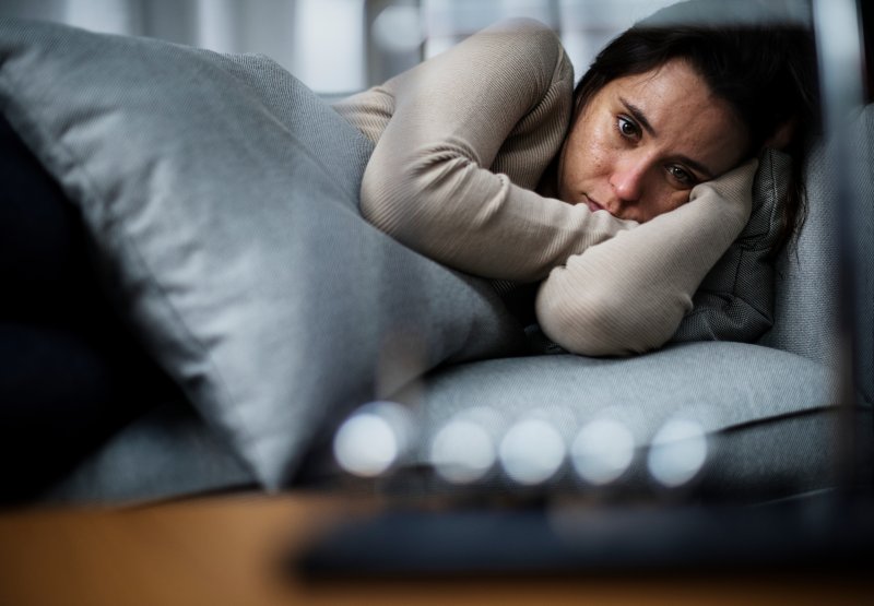 a woman appearing depressed while lying in bed